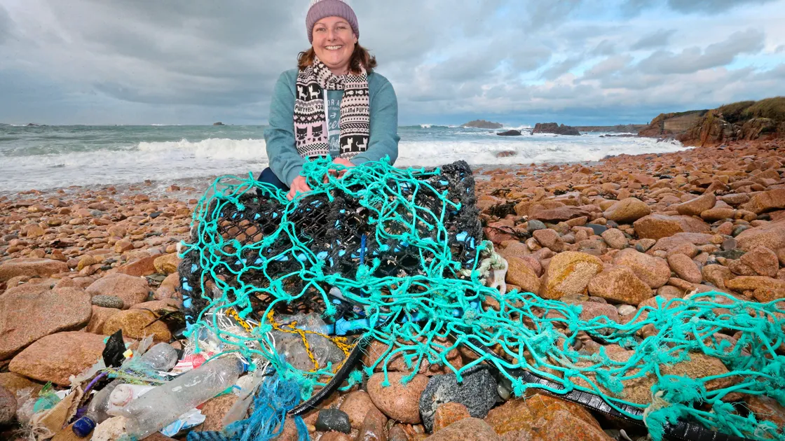 Beachcomber Janet Unitt at Grandes Rocques with a crab pot and a large piece of fishing net which had been washed up there. She has started writing a blog about her interest.(Picture by Steve Sarre, 20316812)