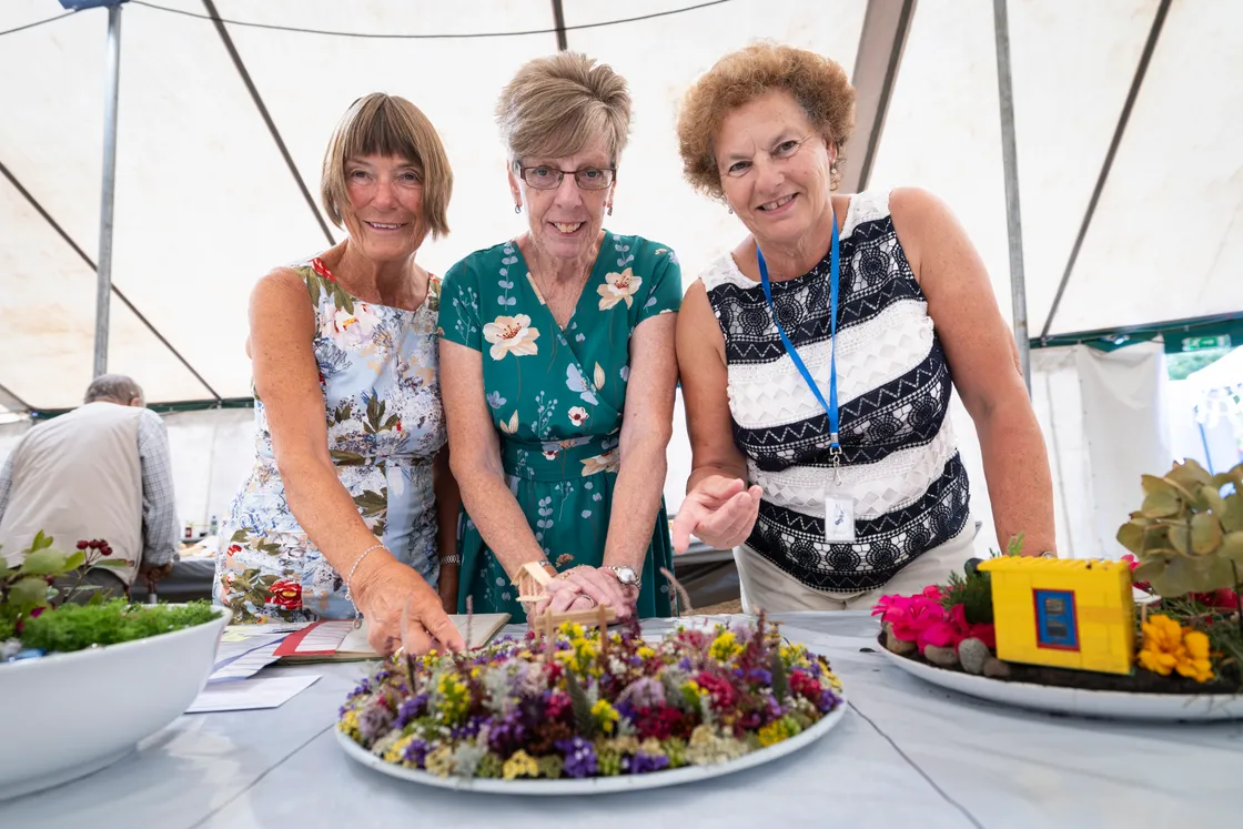 Steward Wendy Wilson, left, with judges Sarah Girard and Lynne Skillett, right, examine the flower arranging and miniature garden displays.
