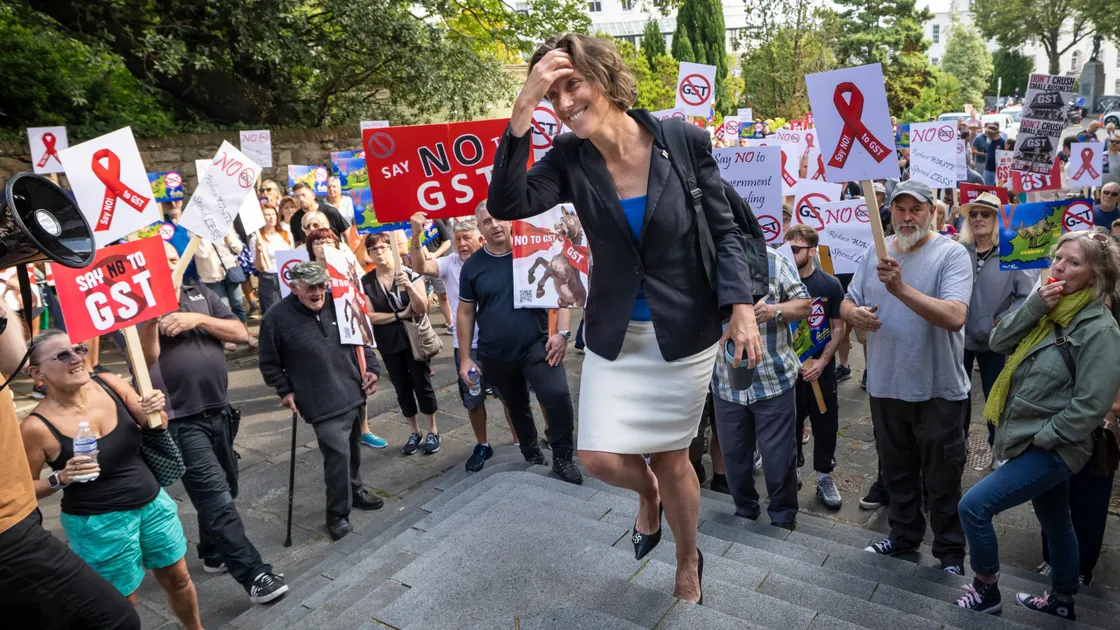 P&R president Lindsay de Sausmarez arrived through a crowd of anti-GST protesters as the States prepared to begin debate on tax reform today.