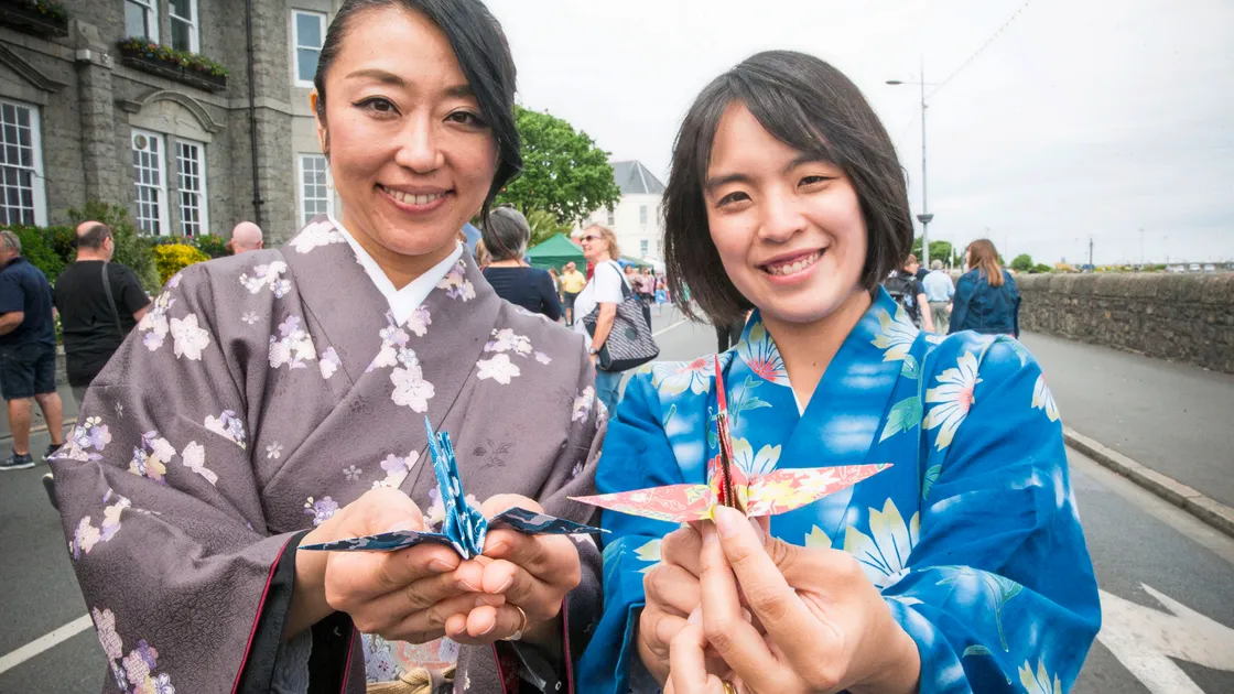 Handing out Origami cranes and sake were Asami Tasaka and Naoko Mauger. (24823772)