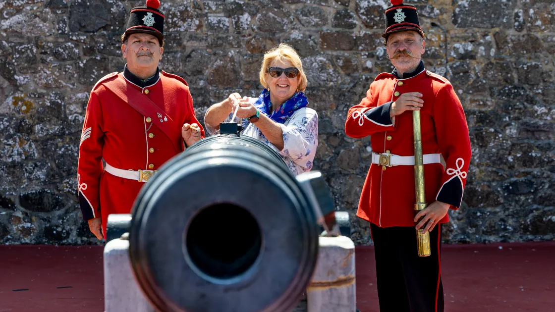 Teacher Sarah Day marked her retirement, having taught at four local primary schools, by firing the Noon Day Gun yesterday. She is pictured with castle keepers Shaun Marsh and Stuart Falla. (Picture by Peter Frankland, 34824053)