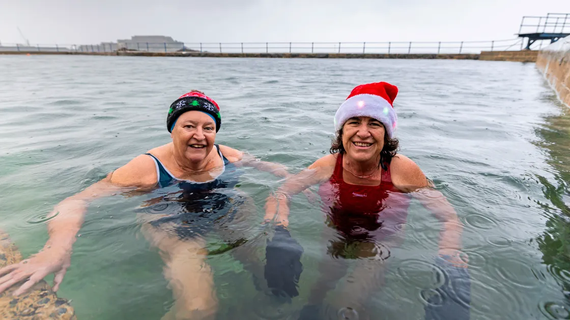 Friends Cathryn Aylett and Lisa Gavey donned Christmas-themed hats as they completed lengths of the pools