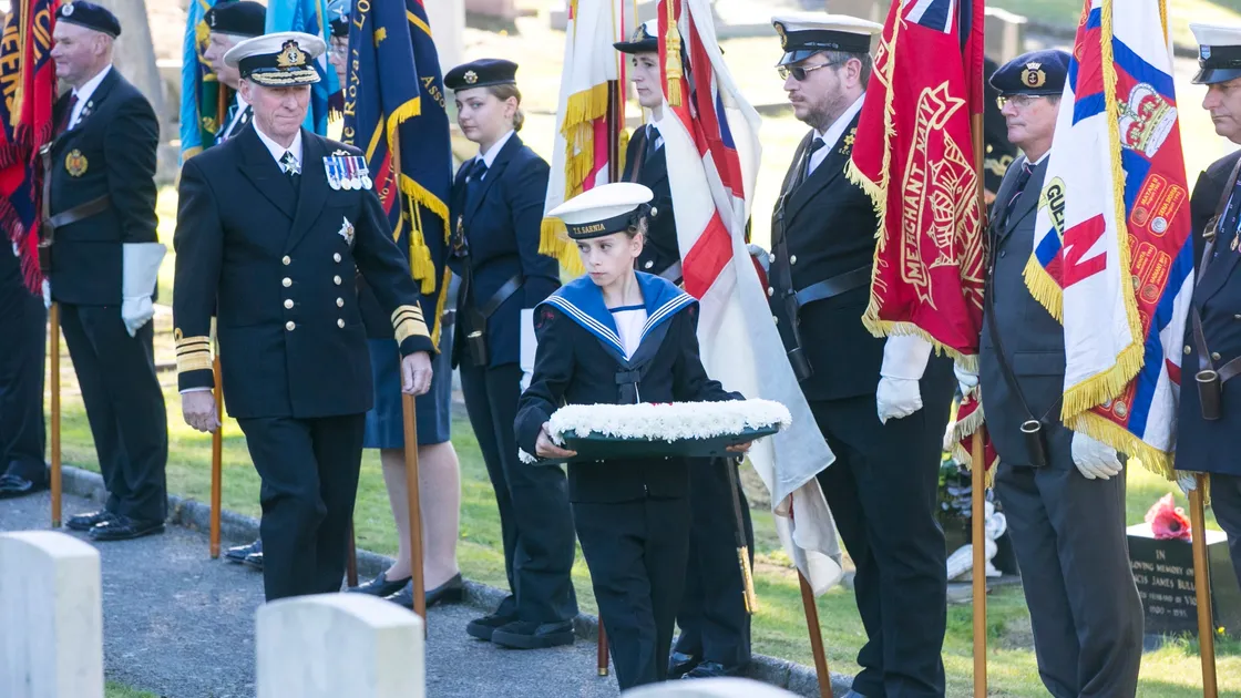 Pic by Adrian Miller 27-09-20 Foulon Cemetery. Remembrance service for H.M.S. Charybdis and H.M.S. Limbourne . Wreath Bearer Cadet Browning 13 of the Sea Cadets leads the Lt Governor Vice Admiral Sir Ian Corder.. (28735063)