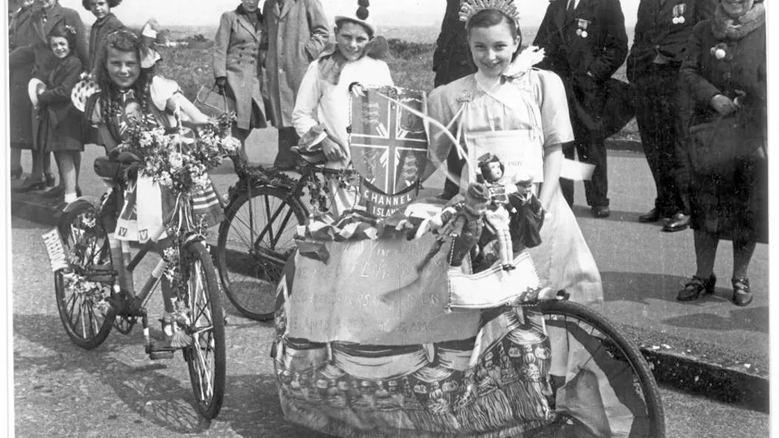 This picture of, left to right, Elizabeth Taylor, John Taylor and Hazel Carre at the end of the cavalcade on the first Liberation Day 74 years ago features on the cover of the new Sure directory.