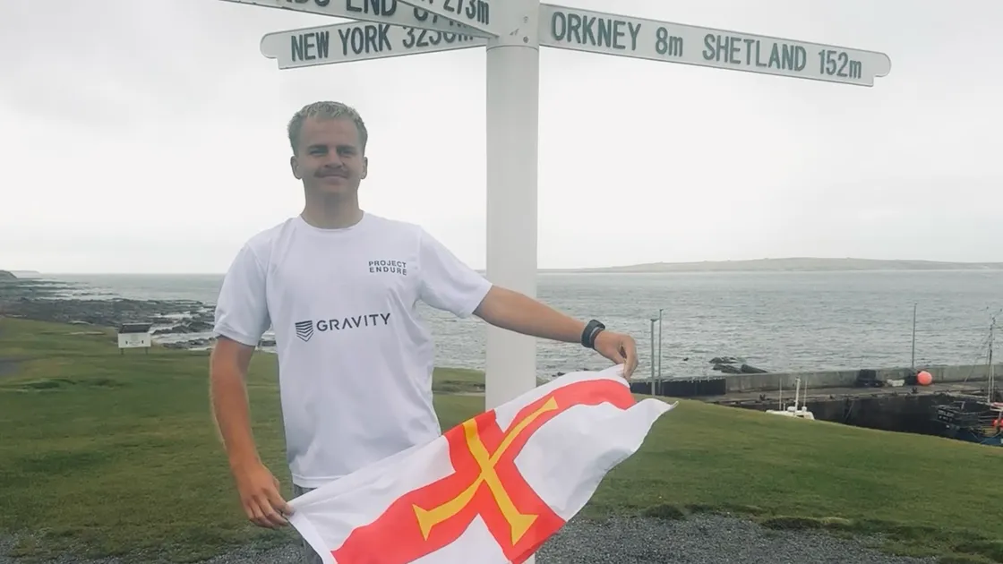 Drew Jonkmans flying the Guernsey flag at John O’Groats, which marked the halfway point of his Project Endure challenge