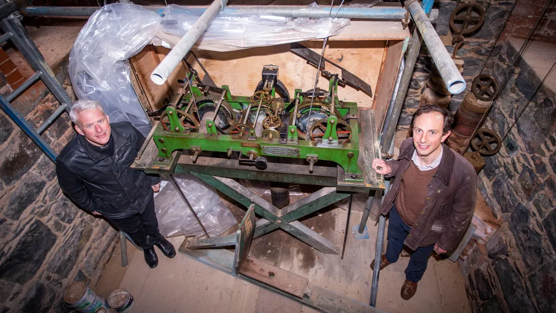 St John’s Church vicar, the Rev. Matthew Barrett, left, and clock specialist Ian Lihou alongside the unique weight-driven clock in the church, which Mr Lihou said would outlast us all. (Picture by Sophie Rabey, 29359768)