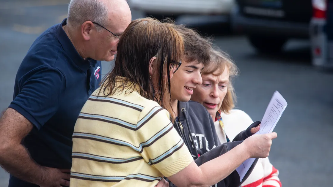 Elizabeth College student Ollie Sparks, 16, shares his results with family. 