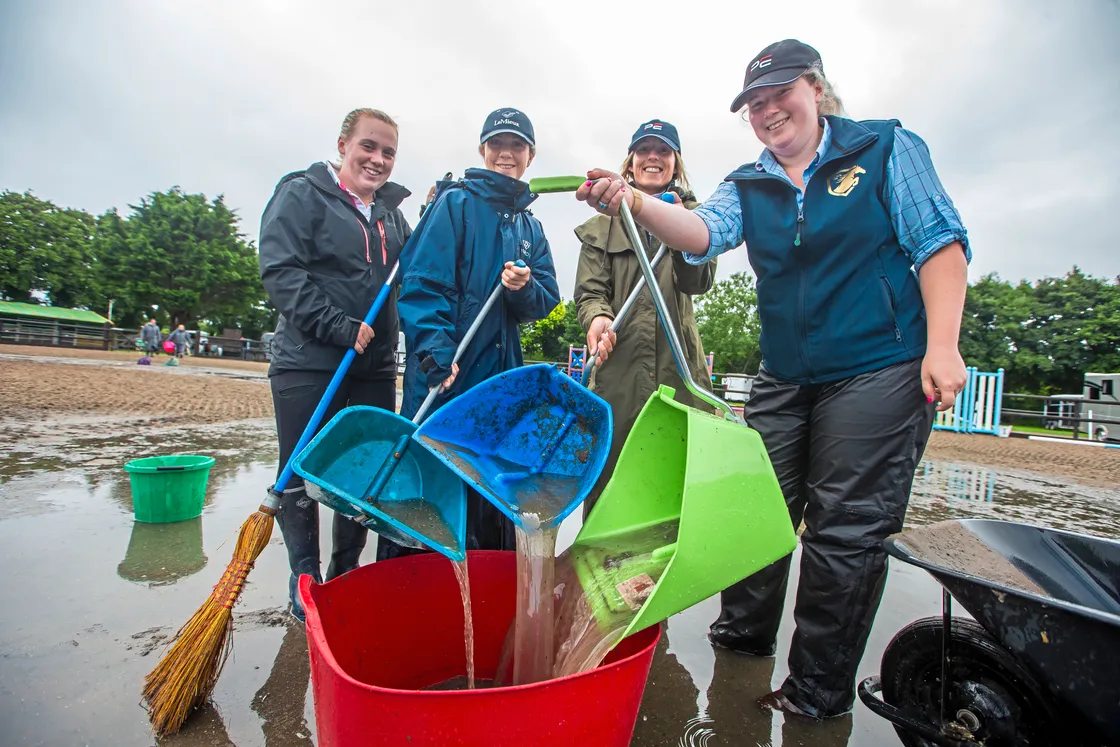 Saturday’s Horse Of The Year show had to be delayed until the ground could be cleared of water. Bailing out by hand are, left to right, Grace Edwards, Sam Rihoy, Sophie Dyer and Nicolle Maltwood. (Picture by Peter Frankland, 33539010)