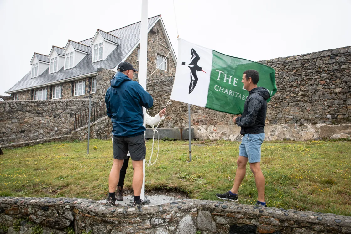 Richard Curtis, Jean Rouget and Steve Sarre (right) raising the new Lihou flag (Picture by Sophie Rabey, 25545015)