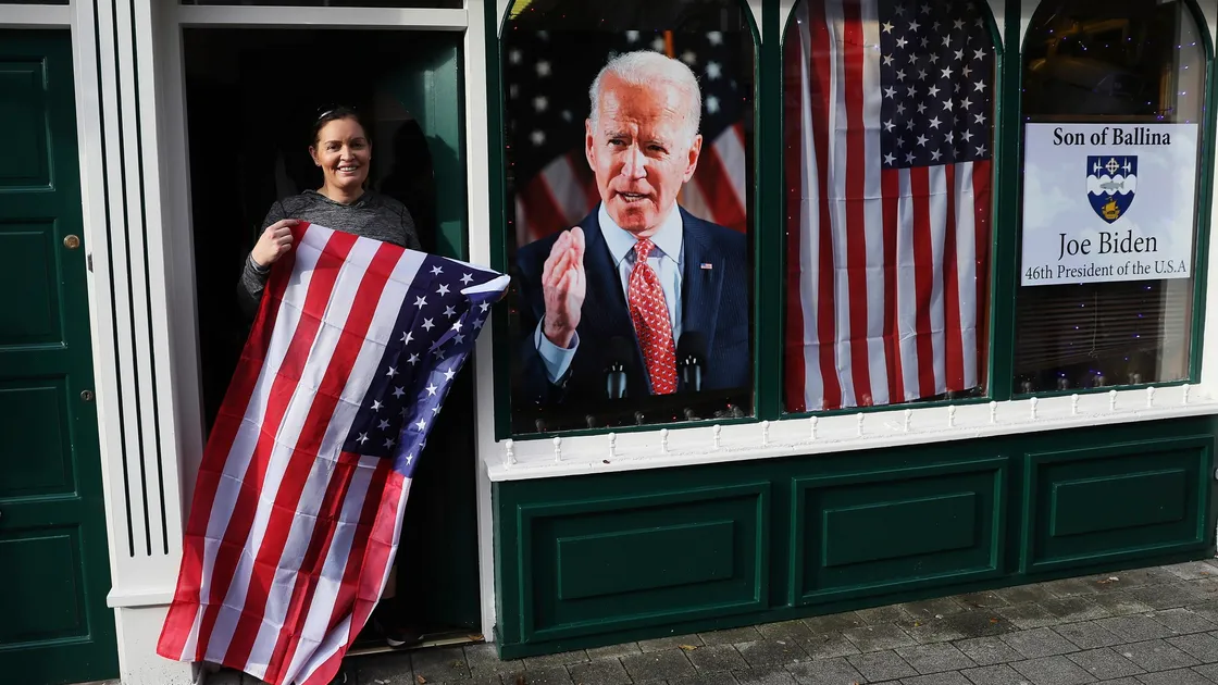 Joe Biden’s election as US president was celebrated in County Mayo, Ireland, his ancestral home. Catherine Hallahan, owner of Hallihan’s barbers, in Ballina, is holding the Stars and Stripes outside her business which has a large picture of the new president in the window. (Picture by Brian Lawless, PA Wire)