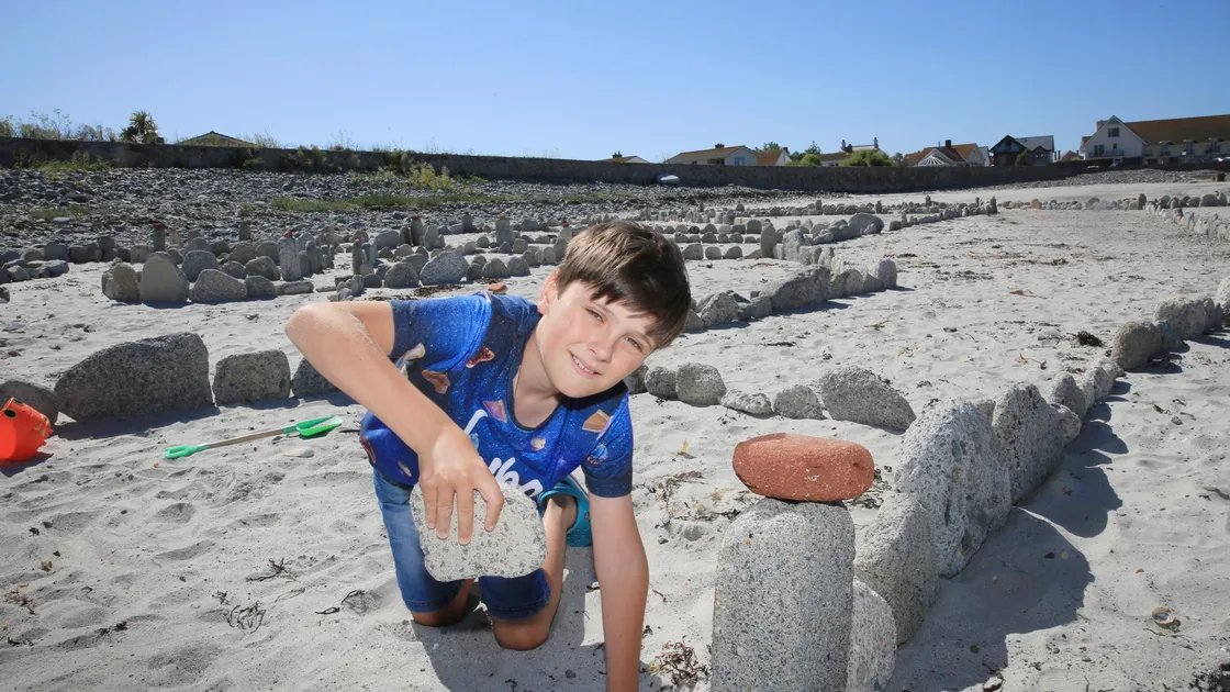 Ten-year-old Max Laine, with the help of his dad Chris, has been building a stone 'fort' on the Richmond end of Vazon and now it is huge. (Picture by Adrian Miller, 28488293)