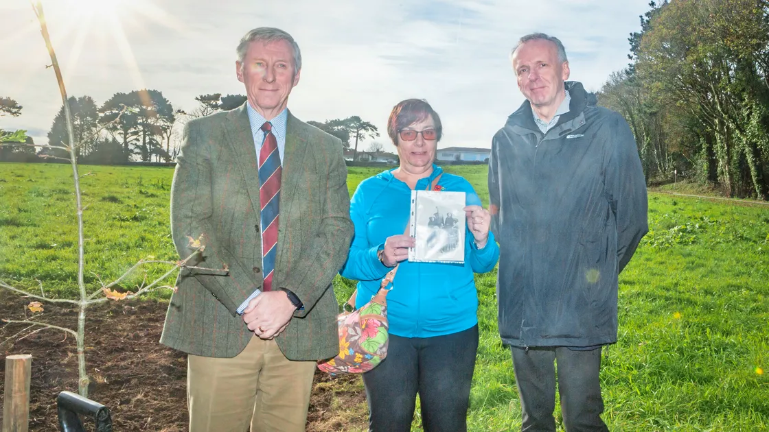 Sandra Robilliard holds the picture of her great-grandfather, Private Alfred Ernest Le Gallez, who served in the Royal Guernsey Light Infantry. Miss Robilliard is pictured with, on the left, Lt-Governor Vice-Admiral Sir Ian Corder, who planted the final tree at a ceremony in memory of the RGLI, and her cousin, Guernsey Press reporter Mark Ogier, who covered the event. (19940455)