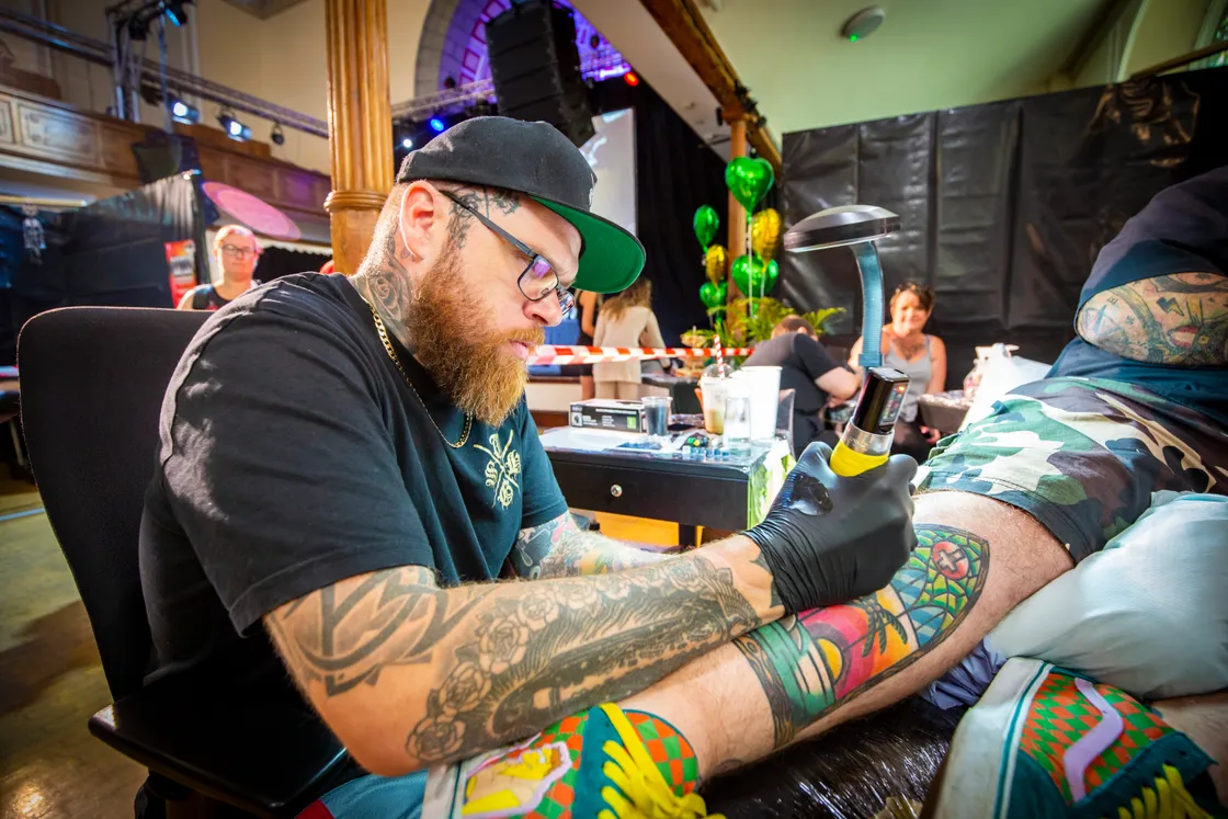 Woodie, from Sacred Hand Tattoo, has been in the industry for nine years. He is seen adding to Neil Etasse’s collection of work. (31018895)