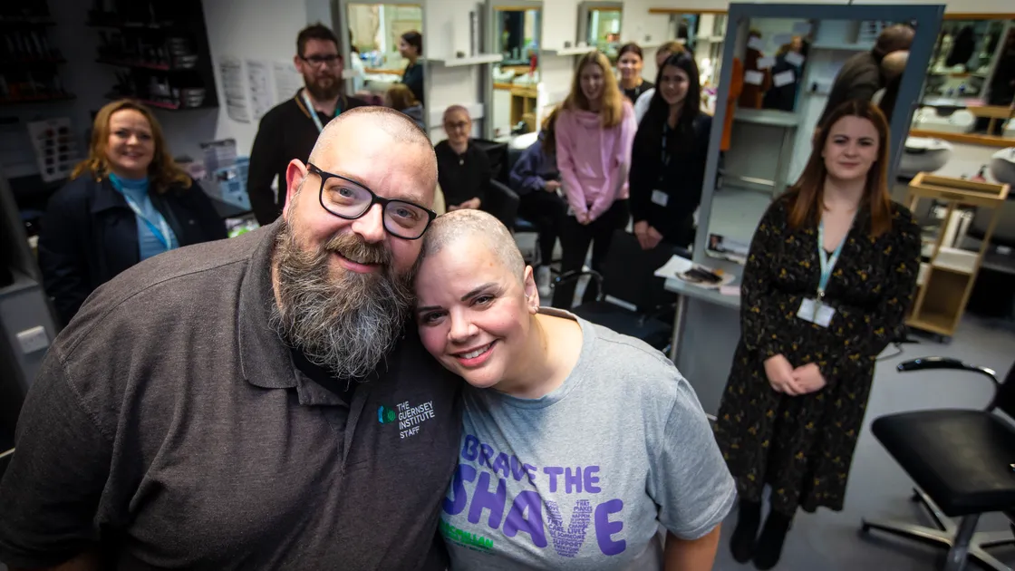 Picture By Peter Frankland. 23-11-22 Martine Ellis and her husband Simon Ellis are having their head's shaved for charity. Martine has alopecia and decided to go for the full shave..They are raising money for McMillan cancer charity. Enya Bessin, heairdressing lecturer at the COFE (right) did the cut. Also pictured are Enya's 1st year apprentice group students and COFE staff.. (31500703)