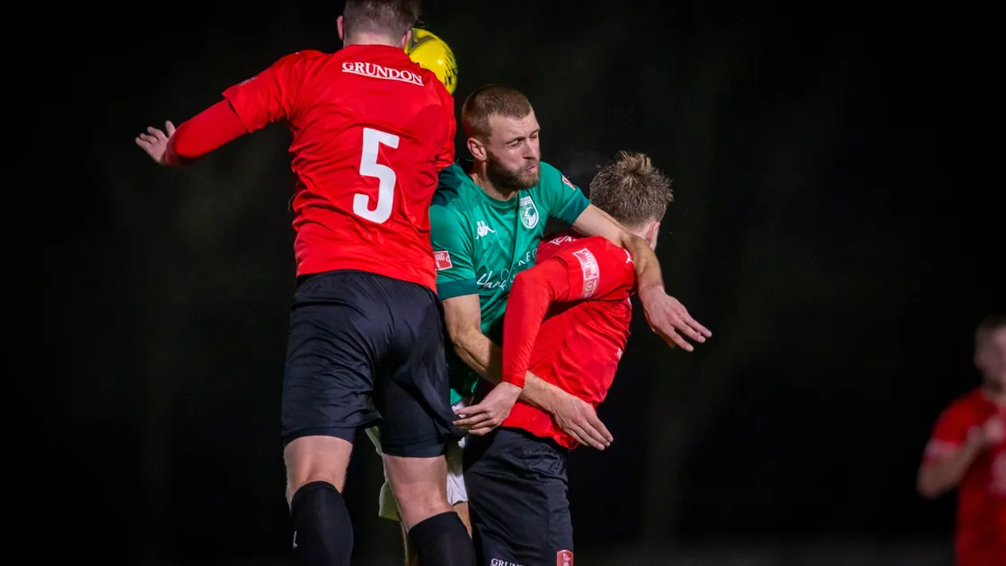 Guernsey FC striker Kyle Smith is the meat in a Bracknell Town sandwich at Footes Lane. (Picture by Sophie Rabey, 30212395)