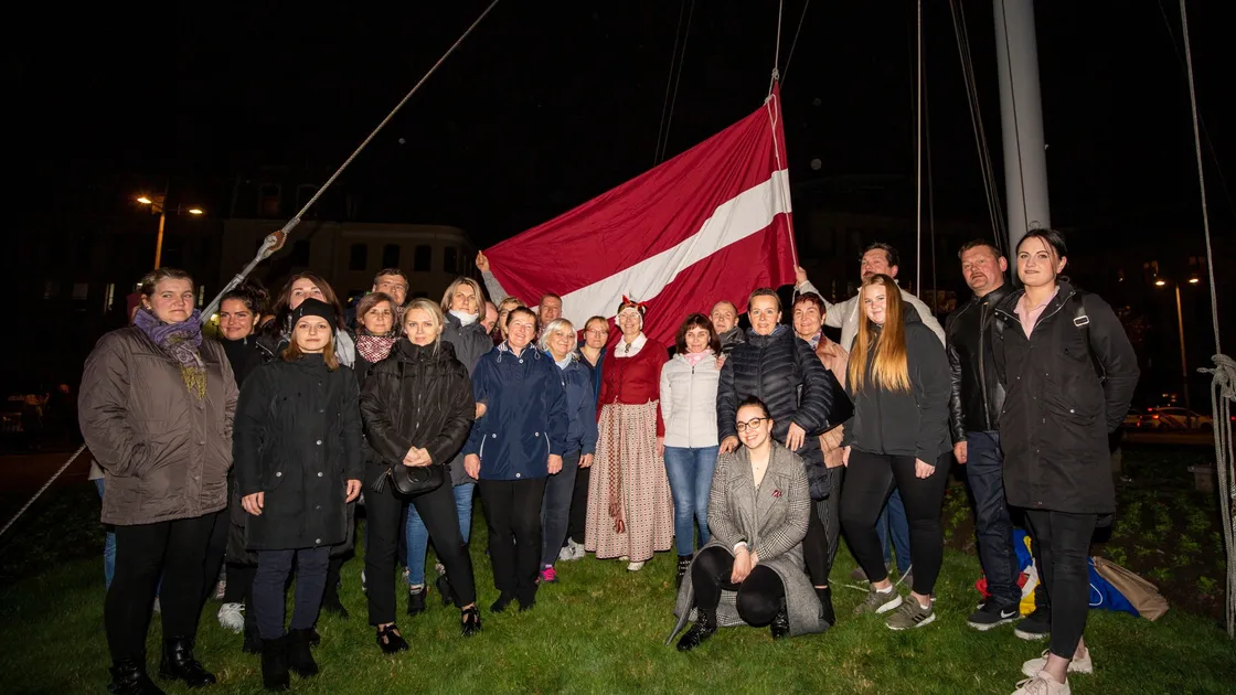 To mark the 103rd anniversary of Latvian Independence Day, the country's national flag was raised on the Weighbridge roundabout mast in St Peter Port. The island's Latvian community gathered for the occasion. (Picture by Sophie Rabey, 30212451)