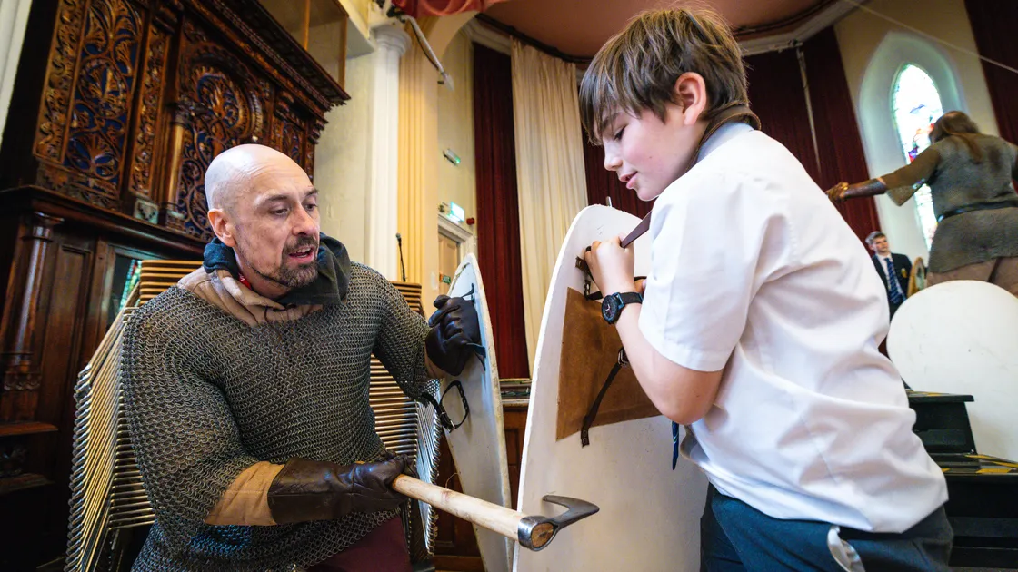 JP Duquemin from the Knight of the Green Isle reenactment group showing some medieval fighting techniques to Elizabeth College pupil Izak Chan.