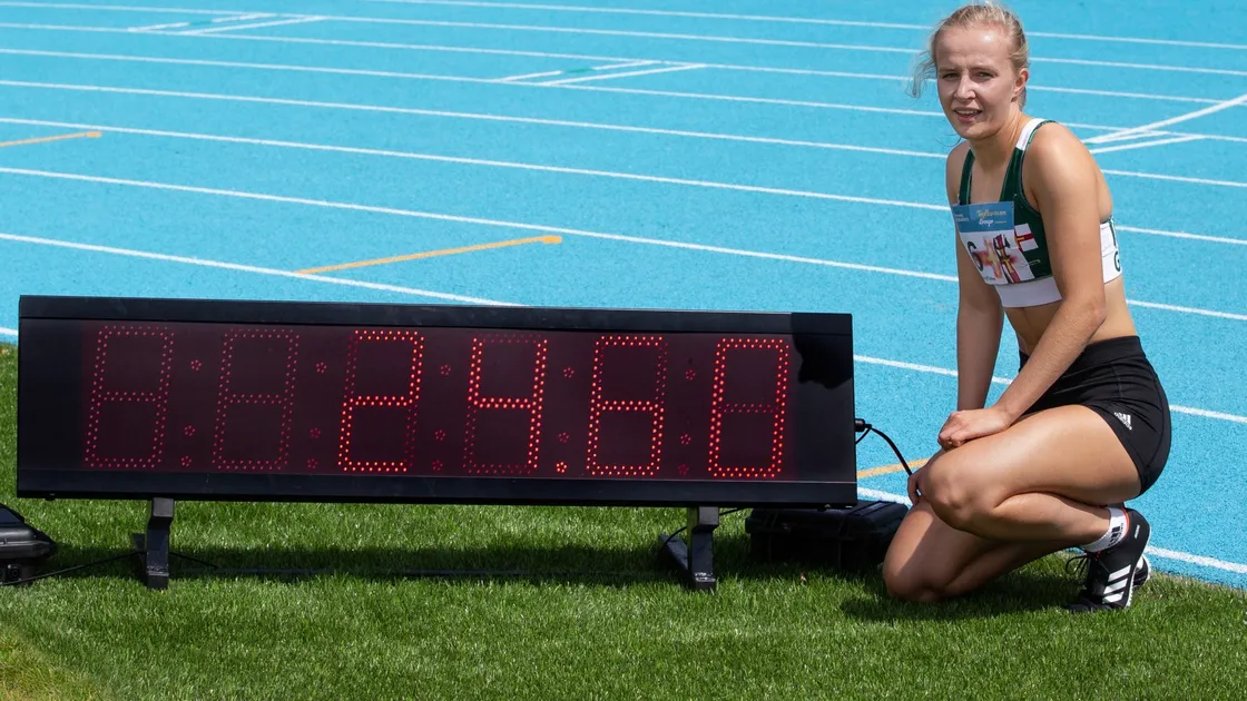 Abi Galpin next to the clock which is displaying her new women's 200m Island record time. (Picture by Martin Gray, www.guernseysportphotography.com, 28536314)