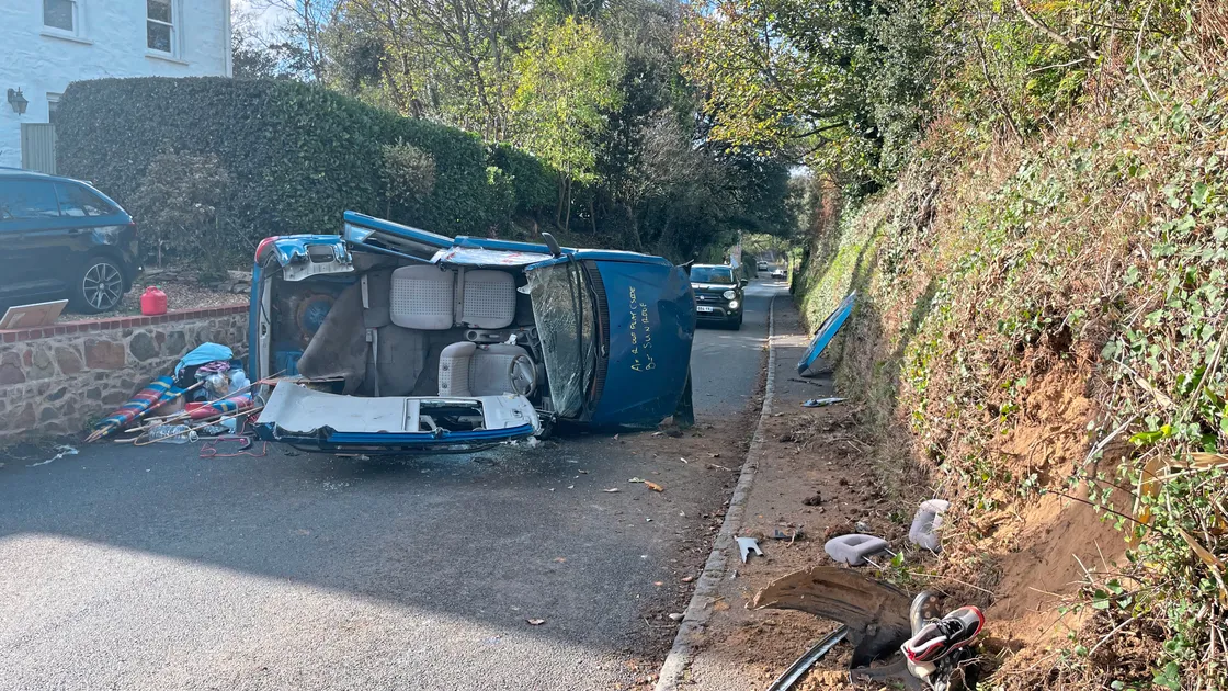 The vehicle on the main road hit the roadside bank and landed on its side. The female driver was trapped inside