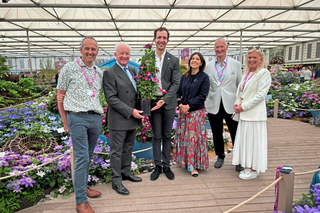 Raymond Evison presenting plants of Clematis Elpis, launched at the show to raise awareness of Prostate Cancer Research and Male Uprising Guernsey. Pictured left to right are Ian Brown from MUG, Raymond Evison, David James from PCR, Nura Valerie Makie from PCR, Mark Chasey from MUG and Erika Chasey from MUG.