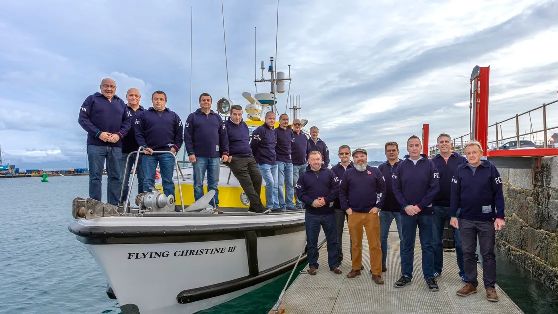 St John's Flying Christine III volunteers pose for a photo with their new Guernsey jumpers. Designed in honour of 25 years of service, the garments will become part of the winter uniform. (Photo by Chris George.)