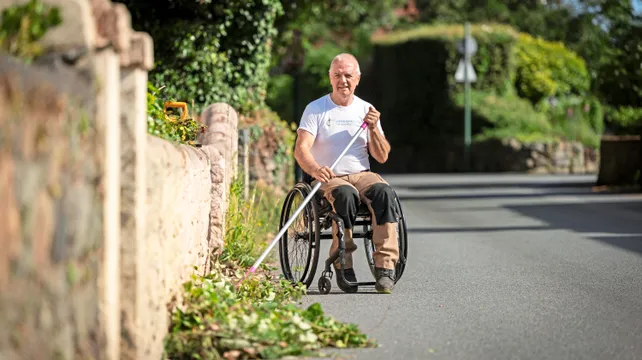 Wheelchair user tackling weeds on island’s roads