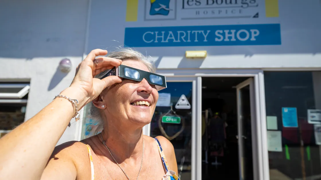 Tina Williams, shop manager at Les Bourgs Hospice Shop, sports a rare pair of eclipse viewing glasses. The shop has sold out of them ahead of today’s event.