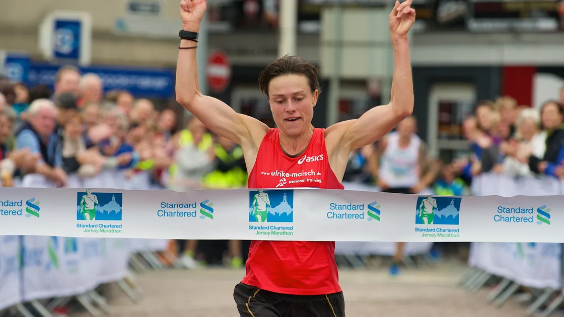 Guernsey’s outstanding distance athlete Ulrike Maisch breasts the tape to win the Standard Chartered Jersey Marathon at the finish at Weighbridge Square. (Picture by Rob Currie, 19484299)