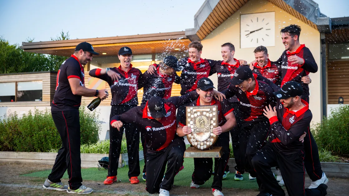 Captain Nathan Le Tissier holds the Rozel Shield while Will Peatfield sprays his Indies teammates with champagne last night at the KGV as they became Evening League champions for the first time. (Picture by Luke Le Prevost, 31053113)