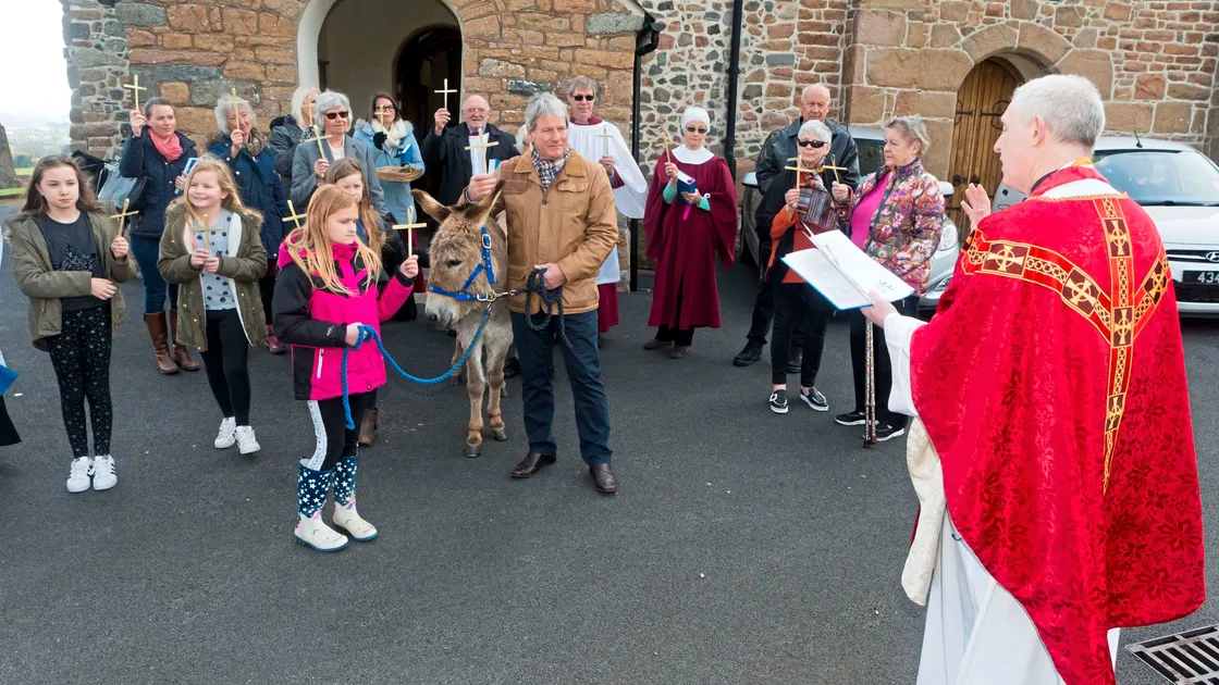 Castel rector the Rev. Scott Innes Lamb conducts the Palm Sunday service in the presence of Mathilda the donkey, who is being held by nine-year-old Charis Burgoyne and churchwarden Chris Workman. (Picture by Steve Sarre, 24408988)
