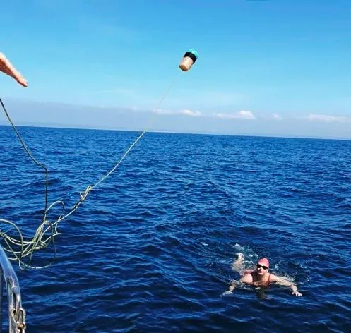 According to Channel swim rules, the swimmer cannot touch the boat or anyone else during the swim, and nobody can touch the swimmer. Sports drinks were thrown from the support boat every half hour to give her energy.