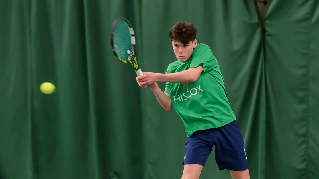 Jack Bachmann hits a backhand from the baseline during Sunday’s U18 inter-insular