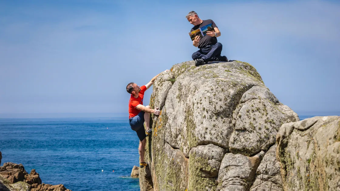 Steve Le Feuvre shows off his bouldering skills while publisher David Price looks on.  