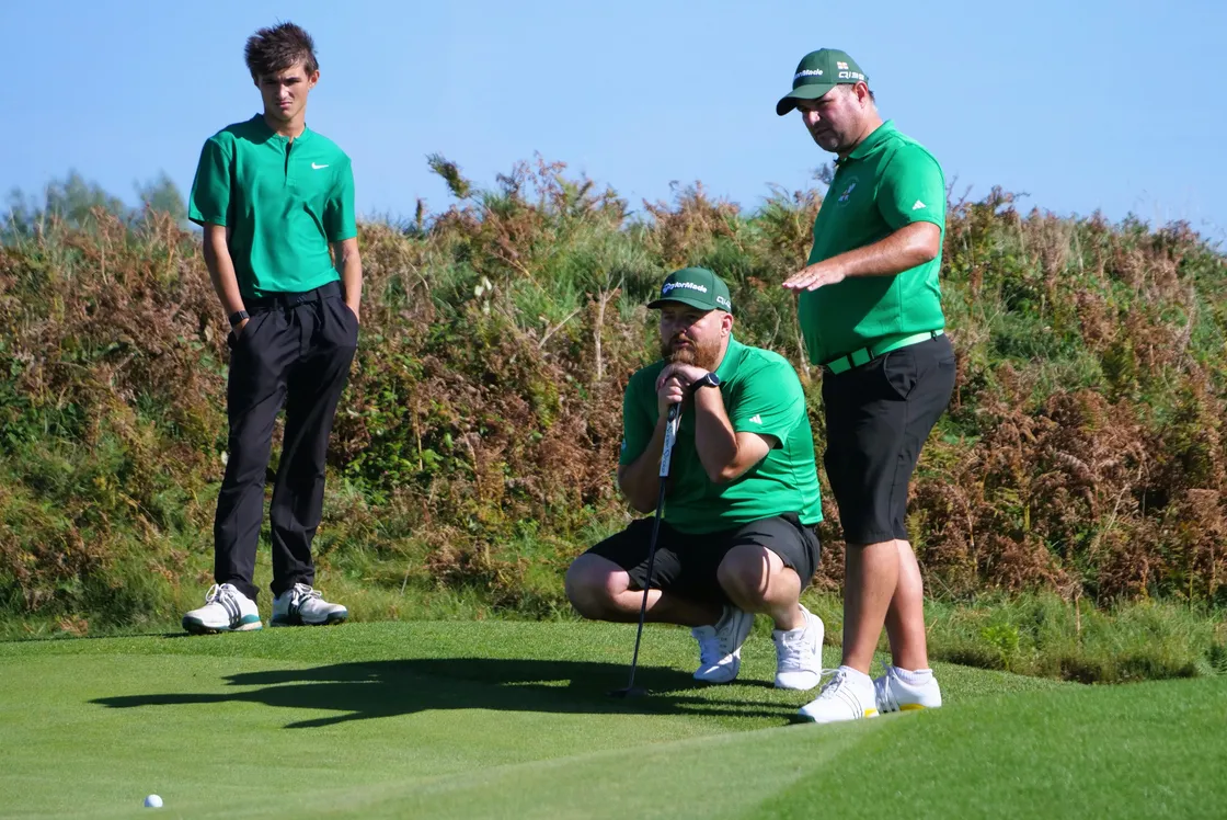 Jamie Blondel and Tom Le Huray, plus caddie Lewis Blondel, line up a putt.