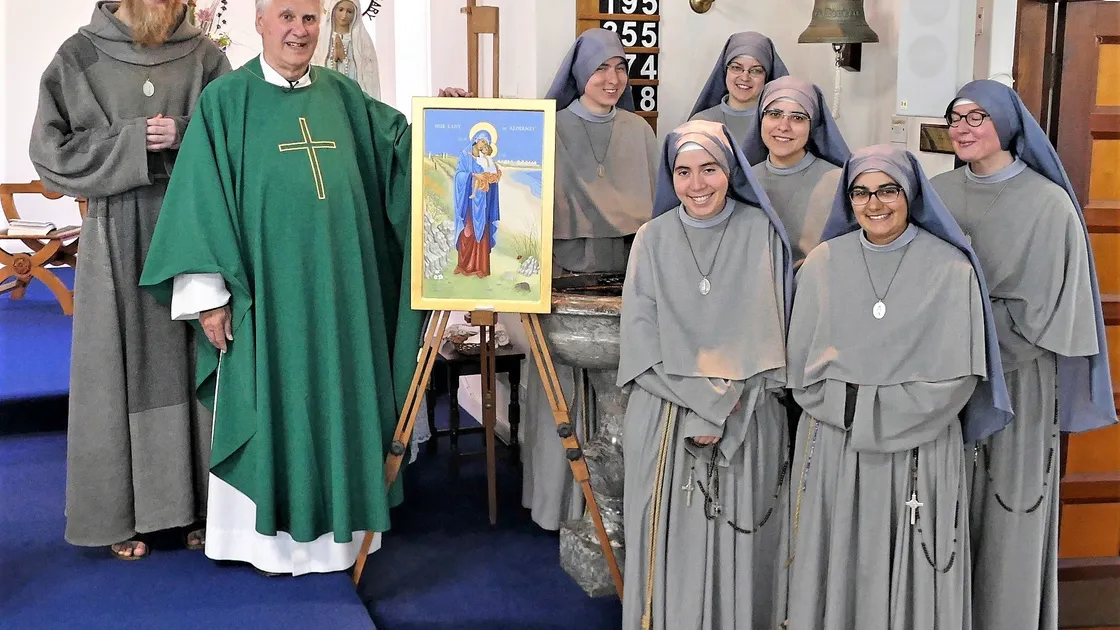 Parish Canon Michael Hore with the artwork he has blessed as his final act before retirement. Our Lady of Alderney is an iconic painting by Annette Ashton Melzack and features a blonde hedgehog and barbed wire. It was gifted to Saint Anne & Saint Mary Magdalen Catholic Church. (Picture by David Nash, 29658527)