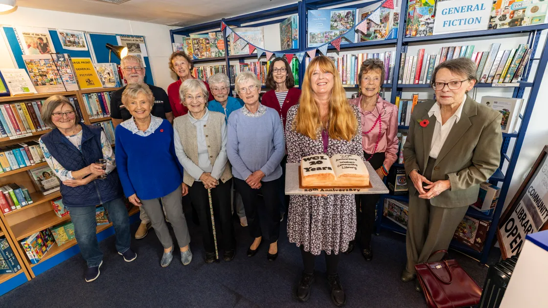 Users and volunteers are pictured with Guille-Alles Library’s community and wellbeing lead Jackie Burgess, who is holding the celebratory cake