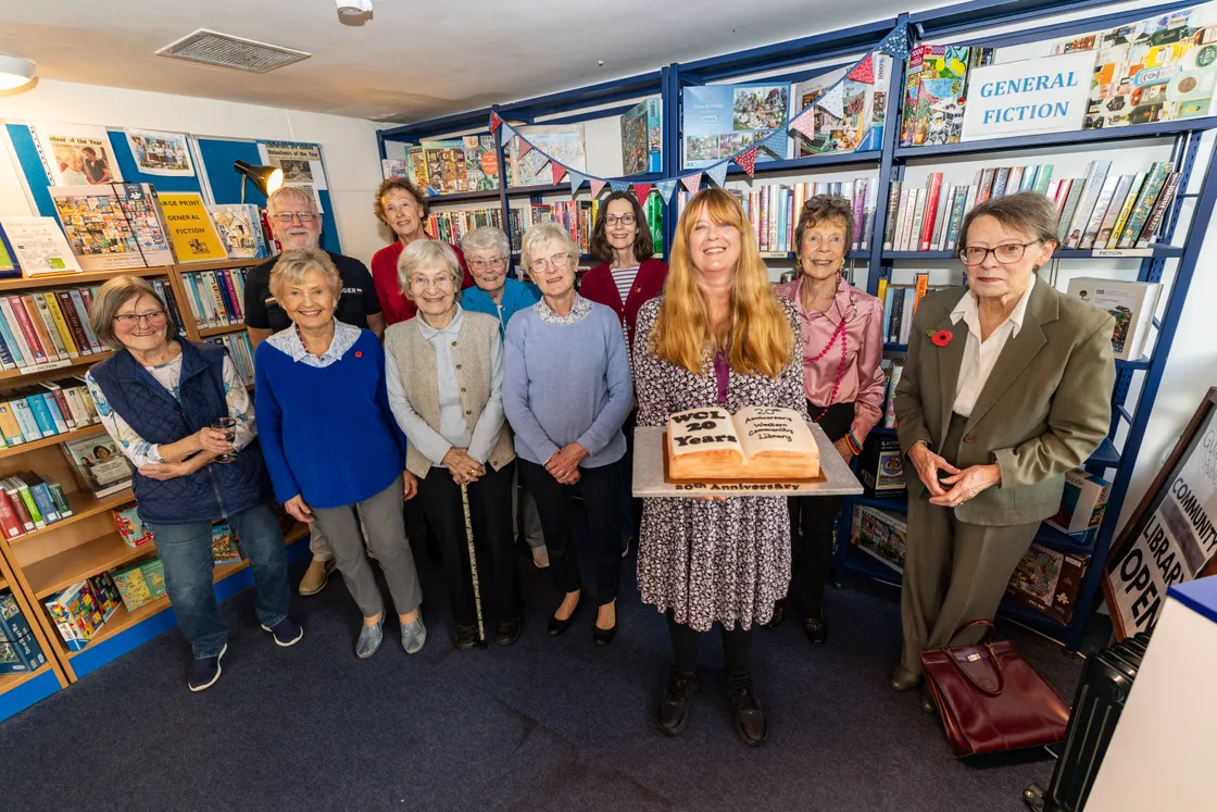 Users and volunteers are pictured with Guille-Alles Library’s community and wellbeing lead Jackie Burgess, who is holding the celebratory cake