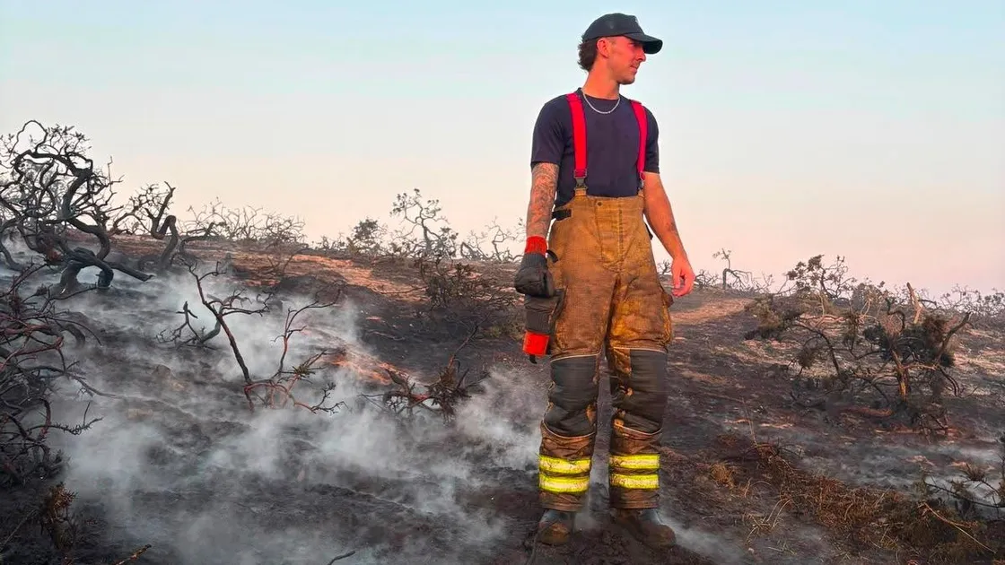 Firefighter Ben Solway stands among the burned fields in Little Sark. 