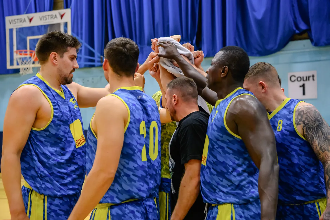 Coach Matt Sawbridge in the middle of a Savills team huddle