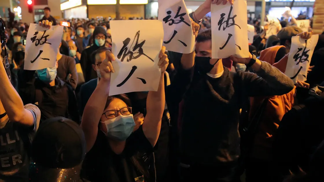 Protesters hold placards baring the words "Release People", shout slogan as they gather near the Polytechnic University in Hong Kong, Monday, Nov. 25, 2019. Hong Kong's pro-democracy opposition won a stunning landslide victory in weekend local elections in a clear rebuke to city leader Carrie Lam over her handling of violent protests that have divided the semi-autonomous Chinese territory. (AP Photo/Kin Cheung). (26466258)