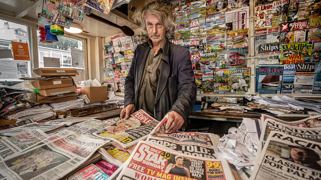 John Brouard, often referred to as ‘The Paper Man’, is currently in hospital after falling ill. Having defied his family's wishes to seek treatment, he collapsed in his kiosk at the bus terminus and was rescued after concerned friends raised the alarm. 	 			 (Picture by Chris George)