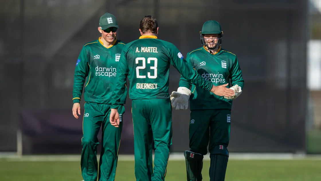 Guernsey wicketkeeper Zak Damarell, bowler Adam Martel and captain Ollie Nightingale celebrate the wicket of Veer Patel.
