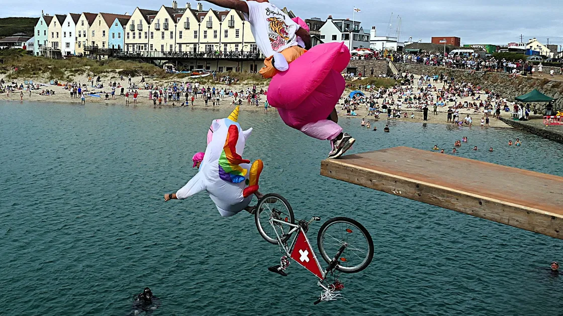 Alderney Week Manpowered Flight event. Swiss visitor Marcel Odermatt the Unicorn uses pedal power to gain some speed followed by his pal Flamingo Ben Sugden as they take off in the Manpower flight competition  in Alderney Week at Braye Beach.												 (Picture by David Nash)