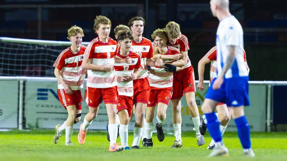 Theo Jones is congratulated by his Elizabeth College teammates last night at the Track after scoring the second goal in their 4-3 win over Bels.